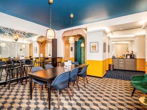 uma sala de jantar com mesa e cadeiras e uma cozinha em ibis Styles Paris Cadet Lafayette em Paris