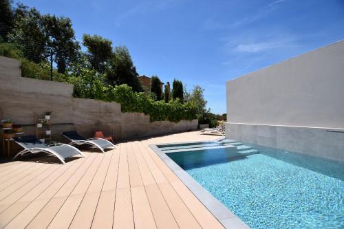 a swimming pool on a patio with chairs and a fence at Casa Lou, architect villa with heated pool at Begur, 470m2 in Begur