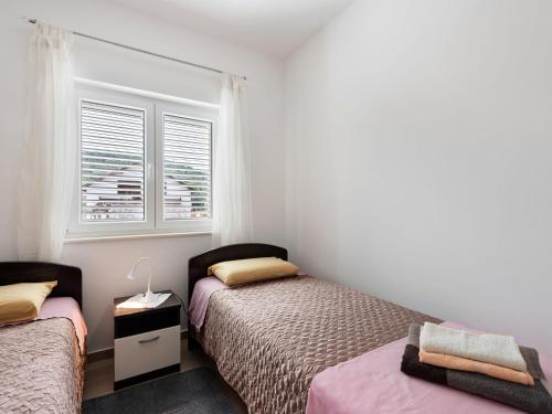 a bedroom with two beds and a window at Simplistic Apartment in Neviđane with Balcony in Neviđane