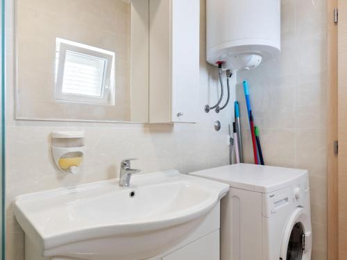 a bathroom with a sink and a washing machine at Simplistic Apartment in Neviđane with Balcony in Neviđane