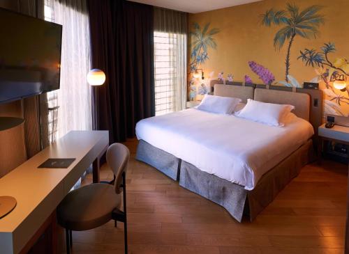 a hotel room with a large bed and a desk at Hotel Villa Emilia in Barcelona