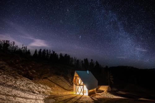 a small wooden cabin under a starry night sky at House On The Hill (Hiška Na Griču) in Spodnja Idrija