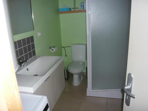 La salle de bains est pourvue d'un lavabo blanc et de toilettes. dans l'établissement Bungalow, à Froidchapelle