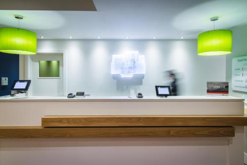 a reception desk with two laptops on top of it at Holiday Inn Stoke on Trent M6 Jct15, an IHG Hotel in Stoke on Trent