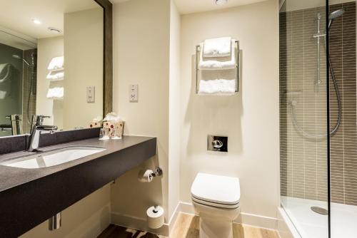 特倫特河畔斯托克的住宿－Holiday Inn Stoke on Trent M6 Jct15, an IHG Hotel，浴室配有卫生间、盥洗盆和淋浴。