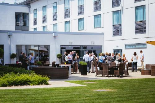 un groupe de personnes debout à l'extérieur d'un bâtiment dans l'établissement Holiday Inn Winchester, an IHG Hotel, à Winchester