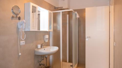 y baño con lavabo y ducha con espejo. en Hotel Venezia Park, en Colà di Lazise