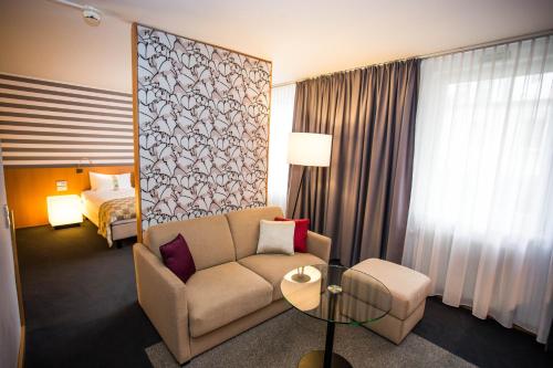 a hotel room with a couch and a bed at Holiday Inn Vienna City by IHG in Vienna