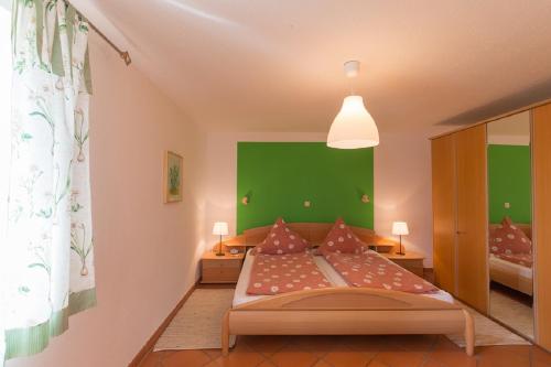 1 dormitorio con 1 cama con pared verde en Ferienhof Lecheler, en Breitenthal
