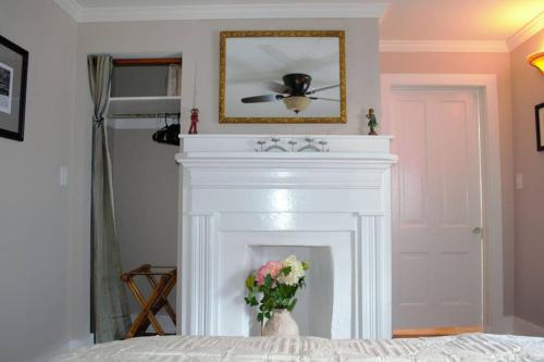 a white fireplace with a flower in a vase at Renovated Historic Loft in the Heart of Downtown in Beaufort