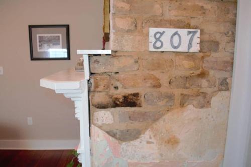 a brick wall with a sign on it at Renovated Historic Loft in the Heart of Downtown in Beaufort