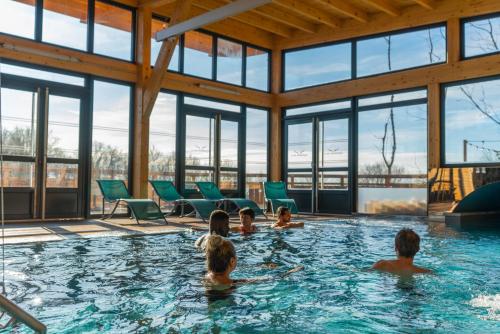 un gruppo di persone in una piscina di Domaine du Hirtz, Restaurant & Spa a Wattwiller