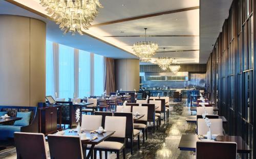 a dining room with tables and chairs and chandeliers at Crowne Plaza Nanning City Center by IHG in Nanning