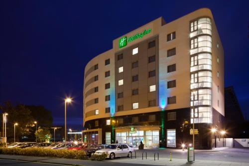 a hotel building with cars parked in a parking lot at Holiday Inn Norwich City by IHG in Norwich