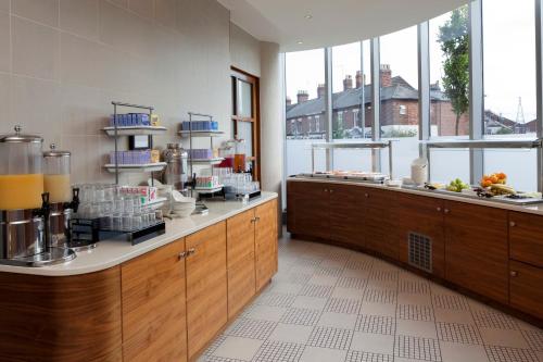 a kitchen with wooden cabinets and aasteryasteryasteryasteryasteryasteryasteryasteryastery at Holiday Inn Norwich City by IHG in Norwich