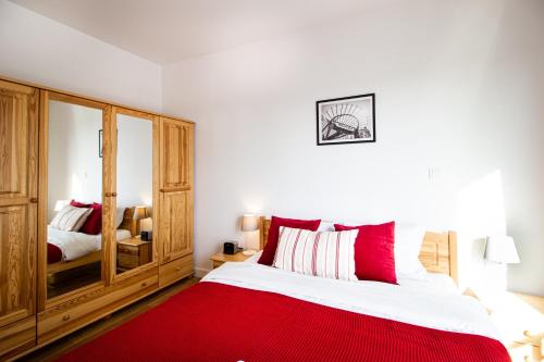 1 dormitorio con 1 cama grande con manta roja en Krasińskiego Żoliborz Stylish Apartment, en Varsovia