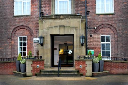 a large brick building with a door and stairs at Holiday Inn Darlington-A1 Scotch Corner by IHG in Scotch Corner