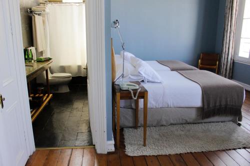 a bedroom with a bed and a table with a lamp at Zero Hotel in Valparaíso