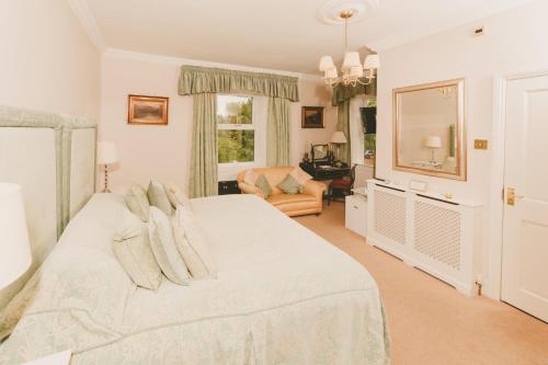 ein Schlafzimmer mit einem großen weißen Bett und einem Stuhl in der Unterkunft Riding Farm in Gateshead