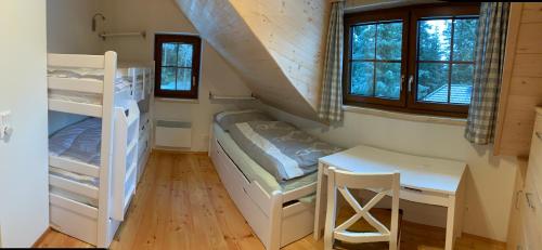 a bedroom with bunk beds and a desk and a table at Almhaus & Almchalet Flattnitz in Flattnitz
