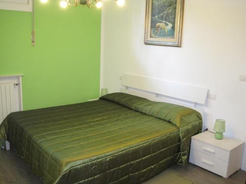 1 dormitorio verde con 1 cama y una foto en la pared en Bed and Breakfast lo Scrigno, en Polinago