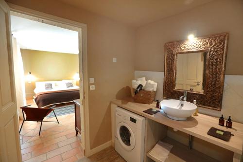 une salle de bain avec un lavabo et une machine à laver dans l'établissement La Maison des Voyageurs, à Arles
