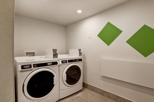 a laundry room with a washing machine and green squares on the wall at Holiday Inn - Ottawa Dwtn - Parliament Hill by IHG in Ottawa