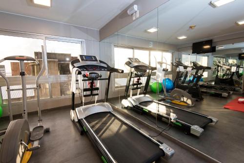 a gym with several tread machines in a room at Holiday Inn Montevideo, an IHG Hotel in Montevideo