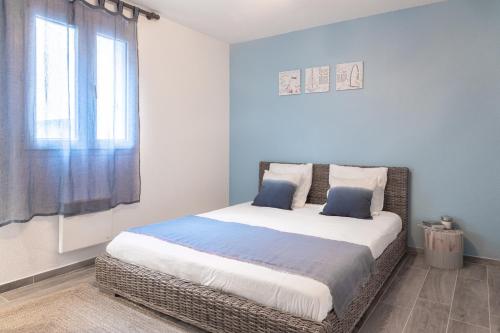- une chambre avec un grand lit aux murs bleus et une fenêtre dans l'établissement Cosy apartment Promenade des Anglais, à Nice