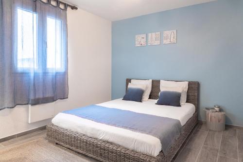 ニースにあるCosy apartment Promenade des Anglaisのベッドルーム1室(青い壁の大型ベッド1台、窓付)