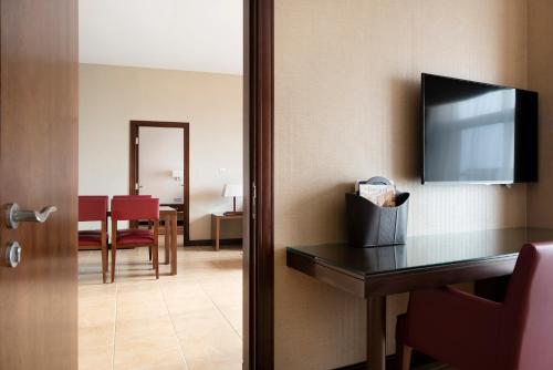 a hotel room with a table and a television at Khalidiya Palace Rayhaan by Rotana, Abu Dhabi in Abu Dhabi