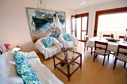 sala de estar con sofá, mesa y pintura en Apartamento Mistral Beach, en El Campello