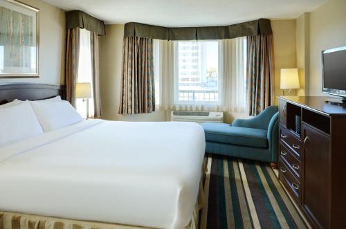 a hotel room with a large bed and a television at Holiday Inn Conference Centre Edmonton South, an IHG Hotel in Edmonton