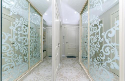 a hallway with glass doors and floral wallpaper at Pechersky Kvartal Apartments in Kyiv