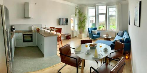 a kitchen and a living room with a table and chairs at Rosen Villa in Kappeln