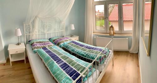 a bedroom with two beds and two windows at Rosen Villa in Kappeln