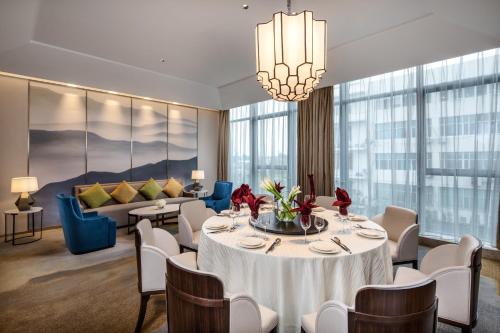 a dining room with a table and chairs and a couch at Holiday Inn Nanjing Harbour by IHG in Nanjing