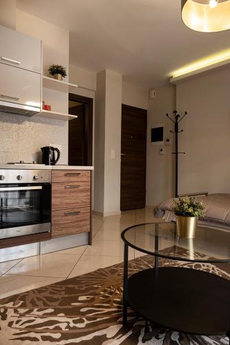 a living room with a table and a kitchen at Antigonidon Square in Thessaloniki