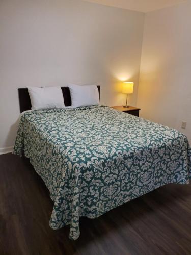 1 dormitorio con 1 cama con manta verde y blanca en Stay Lodge Anderson en Anderson