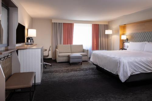 a hotel room with a bed and a chair at Holiday Inn Washington-College Pk I-95 in College Park