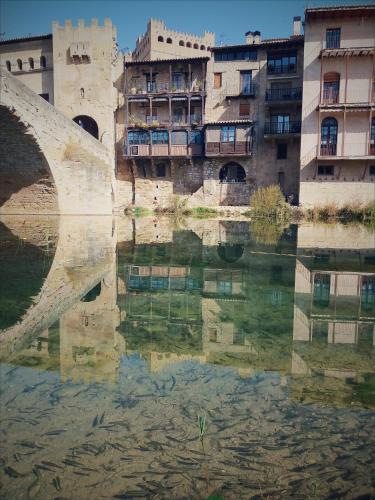a reflection of buildings in a body of water at Mas de Pau - Boutique Apartments in Fuentespalda