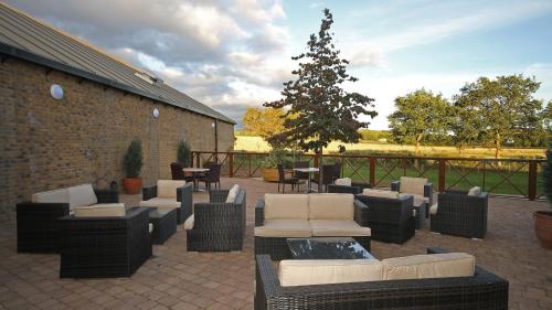 a patio with couches and chairs and a christmas tree at Holiday Inn Huntingdon Racecourse, an IHG Hotel in Huntingdon
