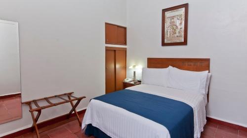 a bedroom with a bed with a blue and white blanket at Holiday Inn Veracruz-Centro Historico by IHG in Veracruz