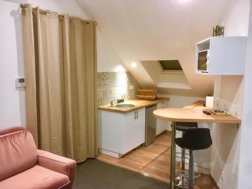 uma pequena cozinha com um lavatório e uma mesa em Sémard em Brive-la-Gaillarde