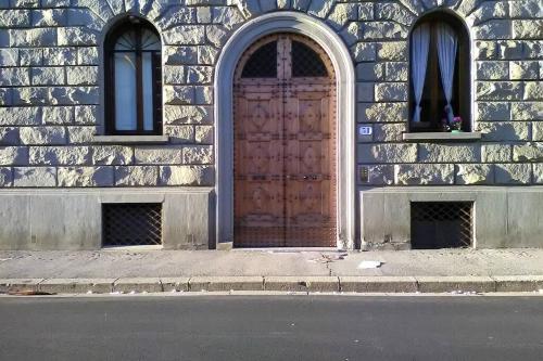 a wooden door on the side of a building with two windows at Charming Family Lodge With Private Garage in Florence