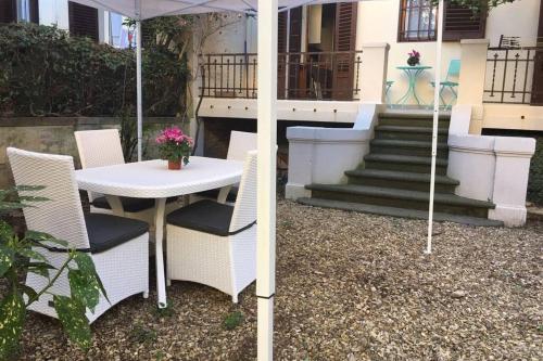 a table and chairs with an umbrella in front of a house at Charming Family Lodge With Private Garage in Florence