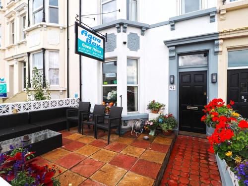 a patio with chairs and a sign in front of a store at Aqua Bay Guest House in Herne Bay