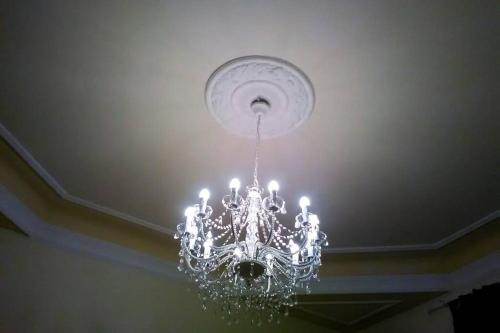 a chandelier hanging from a ceiling in a room at Charming Family Lodge With Private Garage in Florence
