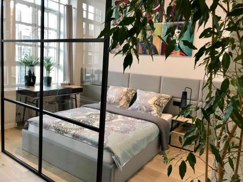 - une chambre avec un lit et une plante dans l'établissement Neon Loft Apartament Bukowskiego, à Białystok