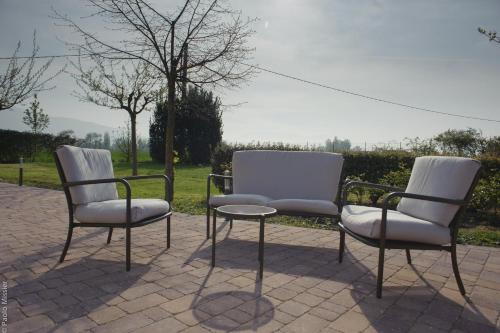 2 sedie e un tavolo su un patio di Agriturismo Il Barco a Spello